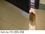 An eco paper bag is standing in the lobby on the doorstep of the apartment. Contactless food delivery to the epidemic. The courier left an online order at the entrance. precautionary measures. Стоковое фото, фотограф Михаил Решетников / Фотобанк Лори