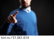 Man in blue sweater points forward, indicating importance in a minimalist setting. Стоковое фото, фотограф Сергей Толмачёв / Фотобанк Лори