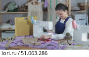 Professional young repairwoman master repairing sewing machine in fashionable sewing studio or bright sewing workshop. Стоковое видео, видеограф Яков Филимонов / Фотобанк Лори
