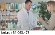 Man pharmacist is working at computer, collaborate with girl client.Electronic database of drugs, international classification of diseases. Detailed list of drugs for treatment of colds. Стоковое видео, видеограф Яков Филимонов / Фотобанк Лори