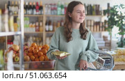 Teenage girl buyer with basket of food choosing products in grocery store. Стоковое видео, видеограф Яков Филимонов / Фотобанк Лори