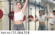 Young woman in sportswear doing warm-up with stick in gym. Стоковое видео, видеограф Яков Филимонов / Фотобанк Лори