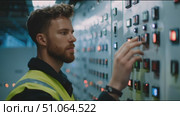 Control panel operation in a facility by technician wearing safety gear. Стоковое AI-видео, аниматор Сергей Толмачёв / Фотобанк Лори