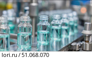 Production line shows glass vials filled with liquid during manufacturing process in industrial facility. Стоковое AI-видео, аниматор Сергей Толмачёв / Фотобанк Лори