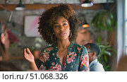 Young African American woman stands in front of a group of people, speaking and gesturing. Стоковое AI-видео, аниматор Данила Большаков / Фотобанк Лори