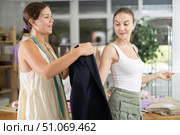 Young tailoress trying ready jacket on female client. Стоковое фото, фотограф Яков Филимонов / Фотобанк Лори