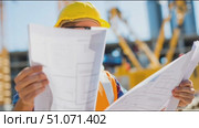 Construction worker reviews plans at job site during bright sunny day. Стоковое AI-видео, аниматор Сергей Толмачёв / Фотобанк Лори