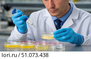 Scientist analyzing microbiological samples in petri dishes using micropipette. Стоковое AI-изображение, AI-художник Юрий Поздников / Фотобанк Лори