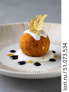 Arancini resting on yogurt cream with balsamic glaze and gold leaf. Стоковое AI-изображение, AI-художник Юрий Поздников / Фотобанк Лори
