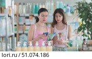 Positive happy mother and daughter buyers at pharmacy holding and choosing best toothbrush, scan QR code. Стоковое видео, видеограф Яков Филимонов / Фотобанк Лори