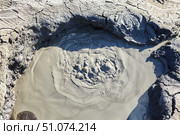 A mud volcano and a stream of grey clay from an eruption and gas escape. Cracked soil surface. Texture of a mudflow. Стоковое фото, фотограф Наталия Кирсанова / Фотобанк Лори