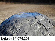 A mud volcano and a stream of grey clay from an eruption and gas escape. Cracked soil surface. Texture of a mudflow. Стоковое фото, фотограф Наталия Кирсанова / Фотобанк Лори