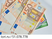 European Euro banknotes and Bank credit cards Visa and Mastercard are located on a white clean surface. Concept of economy and banking system (2020 год). Редакционное фото, фотограф Наталия Кирсанова / Фотобанк Лори