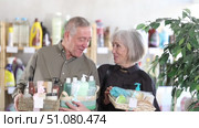 Senior spouses studies label and choose shower cosmetic present, packaged in basket. Стоковое видео, видеограф Яков Филимонов / Фотобанк Лори