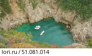 Boats anchored in small emerald cove surrounded by rocky cliffs of Capri Island. Стоковое видео, видеограф Ольга Сухарева / Фотобанк Лори