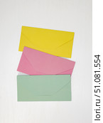 Three pink, yellow and green closed envelopes for money on white background, message concept. Стоковое фото, фотограф Катерина Белякина / Фотобанк Лори