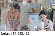 Focused woman fashion designer cutting a piece of fabric before sewing, and dressmaker carefully sewing on a machine in the workshop. Стоковое видео, видеограф Яков Филимонов / Фотобанк Лори