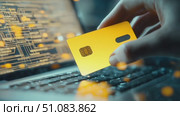 A hand holds a yellow credit card above a laptop keyboard. The background features digital data and circuit patterns, symbolizing online transactions and technology. Стоковое AI-видео, аниматор Nart / Фотобанк Лори