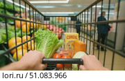 A shopping cart filled with fresh vegetables and cereal in a grocery store aisle. Colorful produce is displayed in the background. Стоковое AI-видео, аниматор Nart / Фотобанк Лори