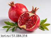 Pomegranates. Pomegranate isolated on a white transparent background. Juicy garnet fruit whole and its half with leaves and details. Piece of pomegranate with seeds. Side view. Freshness and abundance. Стоковое AI-изображение, AI-художник Марина Демидюк / Фотобанк Лори