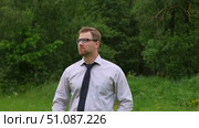 Confident Businessman in Natural Setting. Man stands in front of lush green backdrop. Remote working. Portrait of happy mid adult male wearing formal clothes, shirt and tie, glasses. Find inspiration. Стоковое видео, видеограф Марина Демидюк / Фотобанк Лори