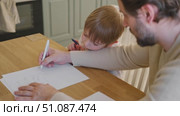 Dad teaches his son writing and counting. Kids primary education. Children learn, study in home school. Daddy male helping teaching little child boy support studying, learning homework. Knowledge day. Стоковое видео, видеограф Марина Демидюк / Фотобанк Лори
