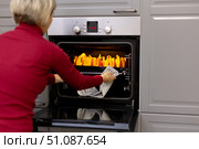 A woman puts a pumpkin cut into slices for baking into the oven. Стоковое фото, фотограф Alexandra Aleroewa / Фотобанк Лори