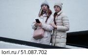 Mother and daughter in the city. Relaxed woman and daughter going to autumn street, sitting on a park bench. Teen girl student wear warm clothes winter jacket. Teenager out for walk with mom. 4K. Стоковое видео, видеограф Марина Демидюк / Фотобанк Лори