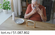Senior Man shaving his face. Old male shaves beard and mustache with shaver. Elderly gray haired man looking at the mirror, applies shaving cream foam and using razor. Skin hygiene. Daily body care. Стоковое видео, видеограф Марина Демидюк / Фотобанк Лори