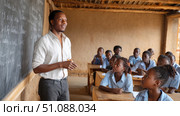 A teacher explaining a science experiment to African students in a modern, well-equipped classroom. Black African children from disadvantaged families study in school, read books, receive primary education, volunteer service. Стоковое AI-изображение, AI-художник ALLA YURTAYEVA / Фотобанк Лори