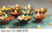 Colorful diya lamps arranged on a decorative surface. The lamps are lit, symbolizing the festival of lights. Ideal for Diwali celebrations and Hindu traditions. Стоковое AI-видео, аниматор Nart / Фотобанк Лори