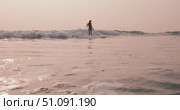 Surfer woman riding on longboard in ocean on small fun wave with sunset sun light. Стоковое видео, видеограф Wonderful nature / Фотобанк Лори