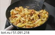 Cooking potatoes fried with chanterelles. Stirring in a frying pan. Process of cooking healthy homemade vegan and vegetarian food with mushrooms. Стоковое видео, видеограф Мария Зубарева / Фотобанк Лори