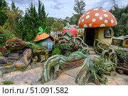 DALAT, VIETNAM - APRIL 29, 2025. Hobbit Village in Fairytale Land park ith colorful fairy-tale houses and tropical plants. Редакционное фото, фотограф Сергей Фролов / Фотобанк Лори