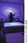 Exploring the Wonders of the Universe: Children Engaged in a Cosmic Learning Experience with an Interactive Galaxy Projection. Стоковое AI-видео, аниматор Владимир Федоров / Фотобанк Лори