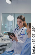 Focused Healthcare Professional Engaged in Patient Care, Utilizing Digital Device to Record Vital Information and Ensure Quality Medical Assistance. Стоковое AI-видео, аниматор Владимир Федоров / Фотобанк Лори