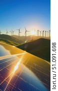 A Breathtaking View of Renewable Energy Sources: Glimmering Solar Panels Reflecting the Sunlight with Turbines Spinning in the Background on a Green Hill. Стоковое AI-видео, аниматор Владимир Федоров / Фотобанк Лори