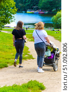 Two women walking with a stroller and a baby. Russia. Moscow. 17.08.25. Редакционное фото, фотограф Ярославский Максим / Фотобанк Лори