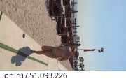 A 50-year-old European woman in a swimsuit walks along the beach in Doha, Qatar. Стоковое видео, видеограф IRYNA ZAKHARANKA / Фотобанк Лори