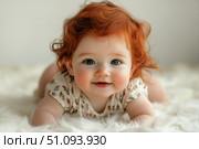 Cute Baby With Curly Red Hair Smiles While Lying on a Soft Blanket Indoors at Home During Daylight. Стоковое AI-изображение, AI-художник Юлия Гапеенко / Фотобанк Лори