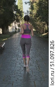Rear view of young woman jogging along shady paved alley in park. Woman is engaged in sports and fitness. Effect of blocked stabilization. LOCKED-ON STABILIZATION EFFECT. Стоковое видео, видеограф Сергей Тимофеев / Фотобанк Лори