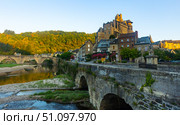French township of Estaing on bank of Lot River with arched bridge and fortified castle. Стоковое фото, фотограф Яков Филимонов / Фотобанк Лори