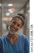 Smiling medical professional in scrubs in a healthcare facility corridor. Стоковое AI-видео, аниматор Сергей Толмачёв / Фотобанк Лори