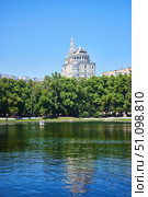 Moscow, Russia. - May 29, 2025: Patriarch's Ponds. "The Patriarch" apartment building is visible in the distance. Редакционное фото, фотограф Наталия Кирсанова / Фотобанк Лори