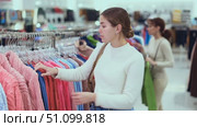 Young woman choosing bathrobe in store. Стоковое видео, видеограф Яков Филимонов / Фотобанк Лори