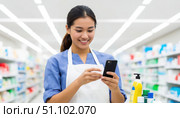 A woman is smiling while looking at her cell phone in a store. Стоковое AI-изображение, AI-художник Ярославский Максим / Фотобанк Лори