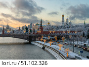 Moscow, Russia, December 31, 2024: Moscow Kremlin and the ensemble of the Kremlin Cathedral Square against the backdrop of the Bolshoy Moskvoretsky Bridge over the Moskva River. Редакционное фото, фотограф Ula Ulachka / Фотобанк Лори