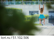 A little girl is playing in the park. Attempt to climb the fence. Стоковое фото, фотограф Наталия Кирсанова / Фотобанк Лори