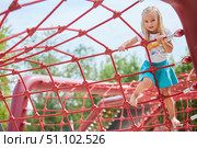 A girl climbs a rope attraction in the park. Entertainment for children. Стоковое фото, фотограф Наталия Кирсанова / Фотобанк Лори