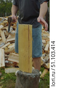Man is cutting firewood with sharp axe, but axe gets stuck in the wood, causing him to have to make extra effort to split the log. Стоковое видео, видеограф Strunov David / Фотобанк Лори